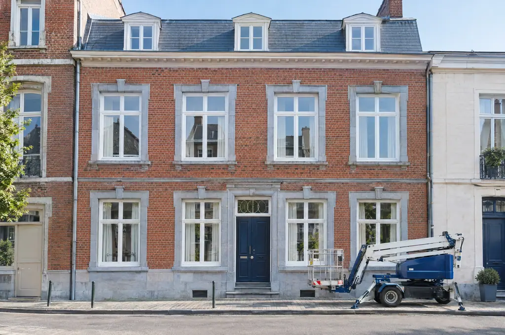 A Namur brick and blue-stone façade freshly cleaned, aerial platform in front